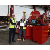 David Neill of TAM International (left) receives a plaque from George Hendry, business development manager for Forum AMC, recognising the purchase of the 350th RT torque machine. (Photo: TAM)