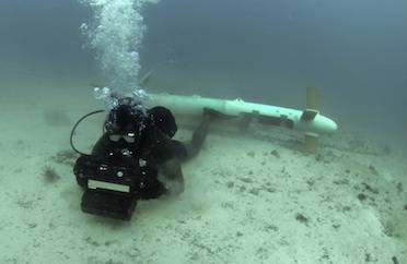 A diver tests underwater imaging system in the Arabian Sea, after an airborne platform "saw" this mine through the water. "The emphasis here," says Dr. Jason Jolliff, an NRL oceanographer who forecasts ocean optics, "is on developing models of the ocean environment to help the naval warfighter." (Photo: U.S. Navy)