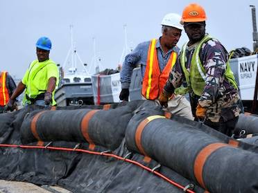 Naval Sea Systems Command stages oil containment booms soon after the Deepwater Horizon blowout. NRL's knowledge, says Dr. Jason Jolliff, "can be applied to a very wide range of forecasting problems, including contaminant distribution and oil spill response." (Photo: U.S. Navy)